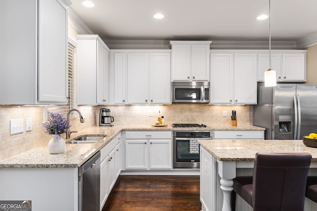 kitchen with sink, white cabinetry, light stone counters, decorative light fixtures, and stainless steel appliances