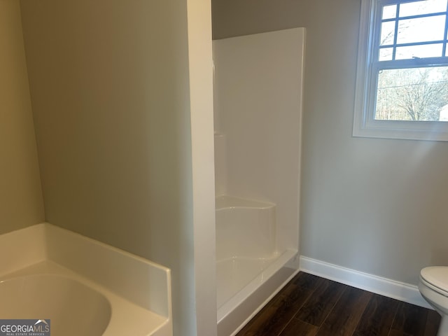 bathroom with wood-type flooring, a shower, and toilet