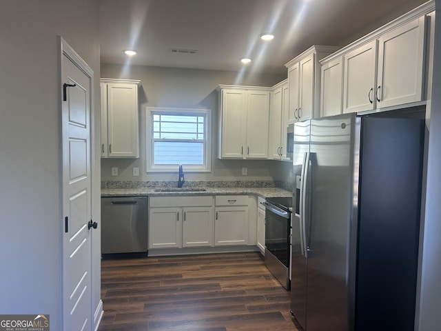 kitchen featuring sink, appliances with stainless steel finishes, dark hardwood / wood-style floors, light stone countertops, and white cabinets