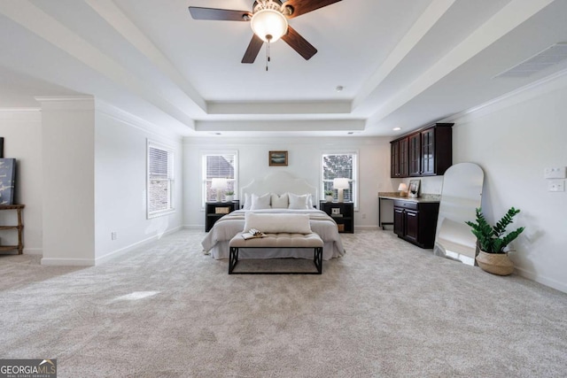 carpeted bedroom featuring a tray ceiling and ceiling fan