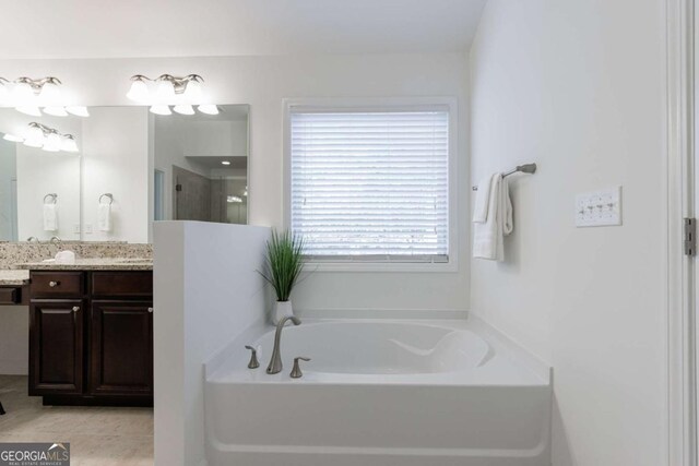 bathroom with vanity, tile patterned floors, and a bathtub