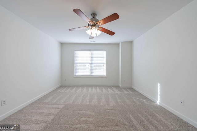 spare room with ceiling fan and light carpet