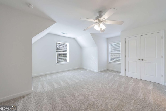 bonus room with light carpet, lofted ceiling, and ceiling fan