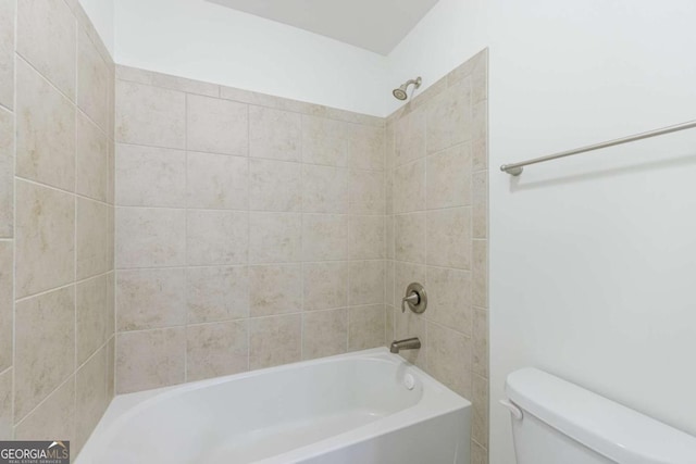 bathroom featuring tiled shower / bath and toilet