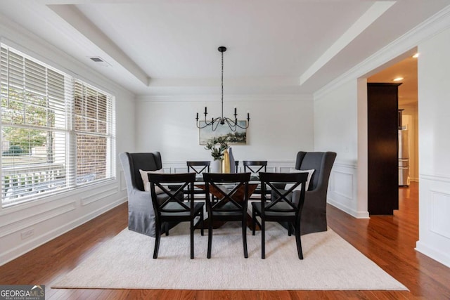 dining area featuring a notable chandelier, a tray ceiling, and dark hardwood / wood-style floors