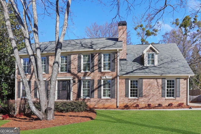 colonial house featuring a front lawn