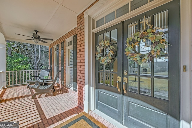 view of exterior entry featuring a porch, ceiling fan, and french doors