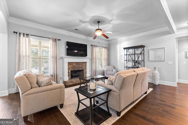 living room featuring ornamental molding, dark wood-type flooring, ceiling fan, and a fireplace