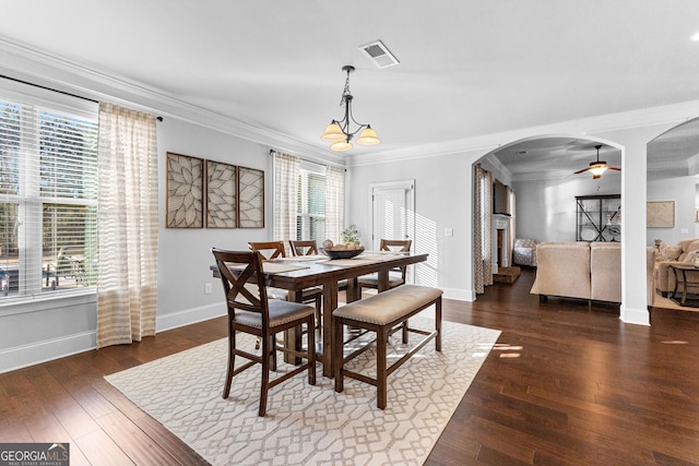 dining space with crown molding, ceiling fan with notable chandelier, and dark hardwood / wood-style flooring