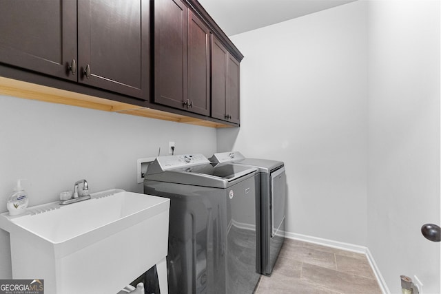 laundry room featuring cabinets, sink, and washing machine and clothes dryer