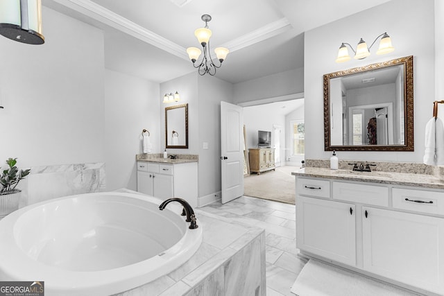 bathroom featuring vanity, ornamental molding, tiled tub, a raised ceiling, and an inviting chandelier