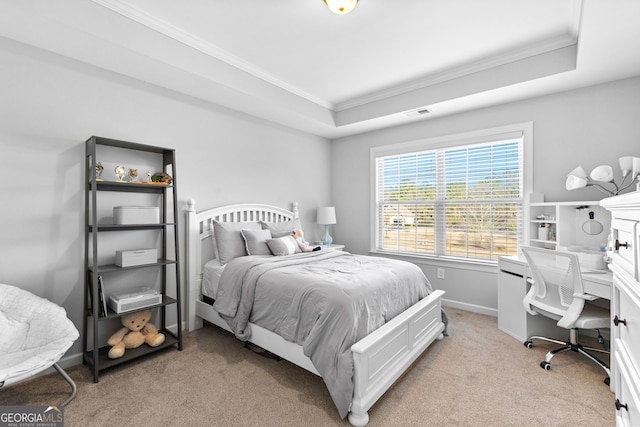 carpeted bedroom featuring crown molding and a tray ceiling