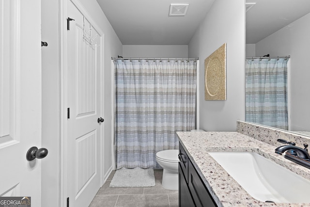 bathroom with tile patterned flooring, vanity, and toilet