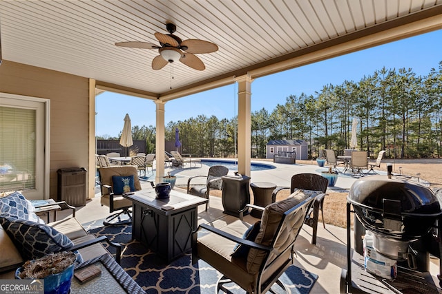 view of patio / terrace with a grill, ceiling fan, and a storage unit