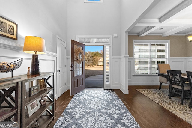 entryway with coffered ceiling, beam ceiling, a wealth of natural light, and dark hardwood / wood-style floors