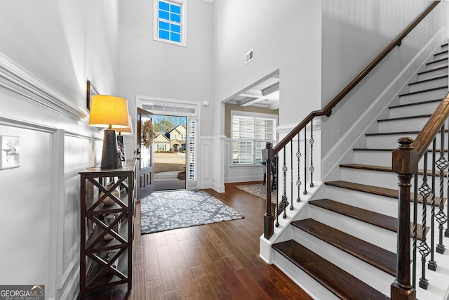 entryway with dark hardwood / wood-style flooring and a high ceiling