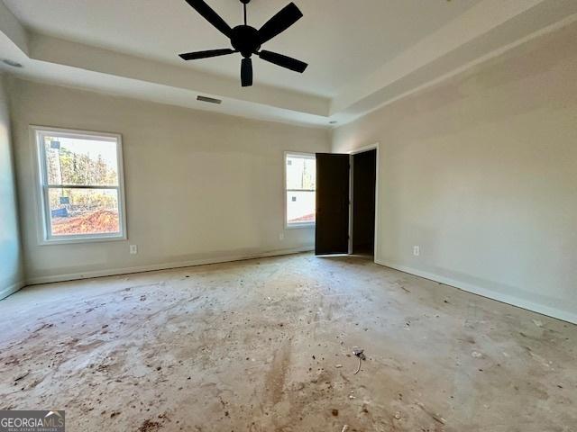 unfurnished room with a tray ceiling and ceiling fan