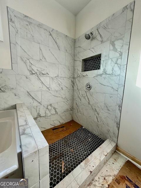 bathroom featuring a tile shower and sink