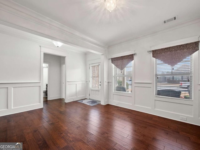 empty room with hardwood / wood-style flooring and ornamental molding
