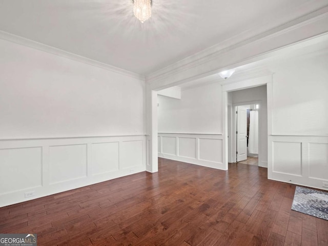 spare room featuring crown molding and dark wood-type flooring
