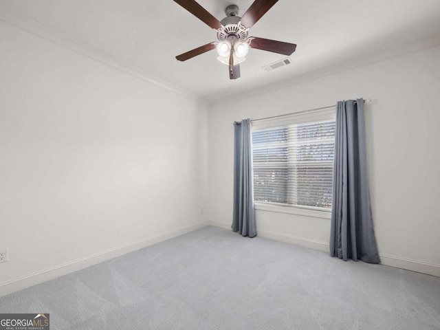 unfurnished room featuring crown molding, light colored carpet, and ceiling fan