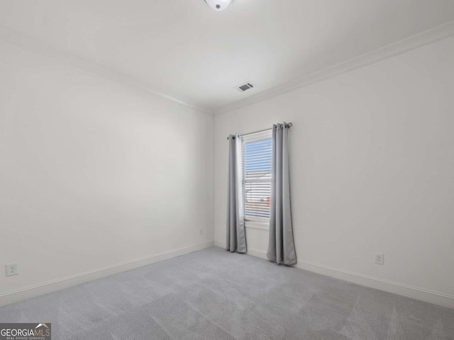 carpeted spare room featuring crown molding