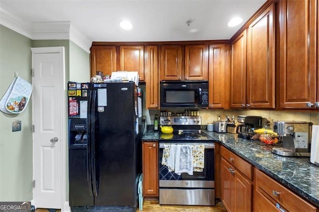 kitchen featuring dark stone countertops, ornamental molding, and black appliances