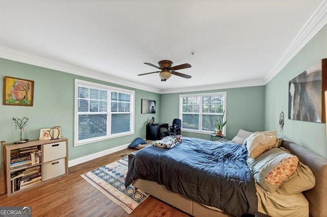 bedroom featuring crown molding, dark wood-type flooring, and ceiling fan