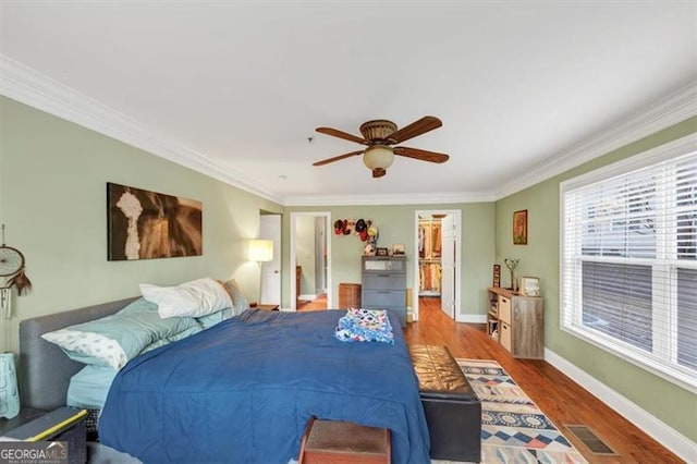 bedroom featuring dark hardwood / wood-style flooring, ornamental molding, and ceiling fan