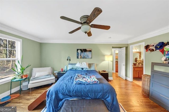 bedroom with hardwood / wood-style flooring, ornamental molding, and connected bathroom