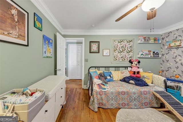 bedroom featuring hardwood / wood-style flooring, crown molding, and ceiling fan