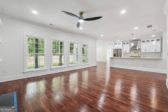 unfurnished living room featuring ceiling fan, dark wood-type flooring, visible vents, baseboards, and crown molding