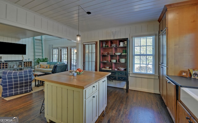 kitchen featuring hanging light fixtures, dark hardwood / wood-style floors, butcher block countertops, and a kitchen island