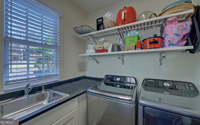 laundry area featuring cabinets, sink, and washing machine and dryer