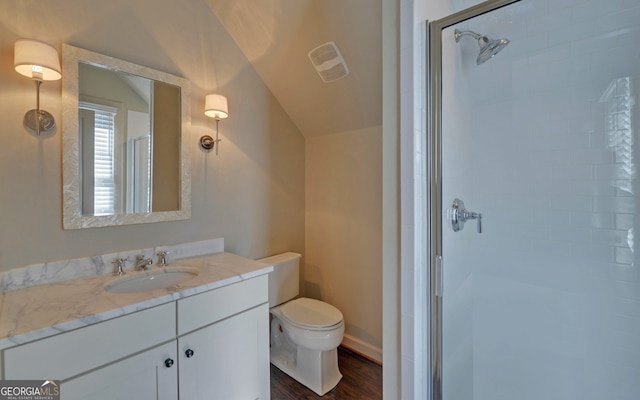 bathroom with vaulted ceiling, hardwood / wood-style floors, vanity, toilet, and a shower with door