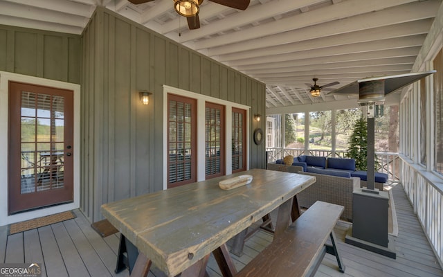 sunroom / solarium featuring ceiling fan, a healthy amount of sunlight, and lofted ceiling with beams