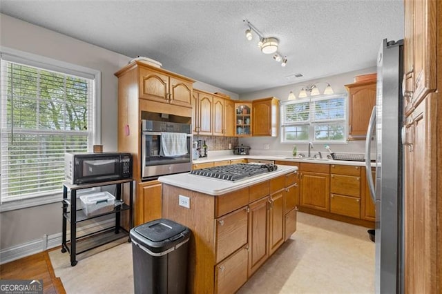 kitchen featuring sink, plenty of natural light, appliances with stainless steel finishes, and a kitchen island