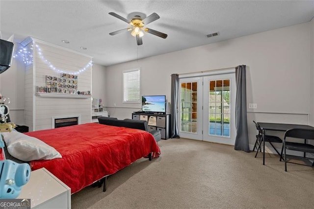 carpeted bedroom featuring multiple windows, ceiling fan, access to outside, and a textured ceiling