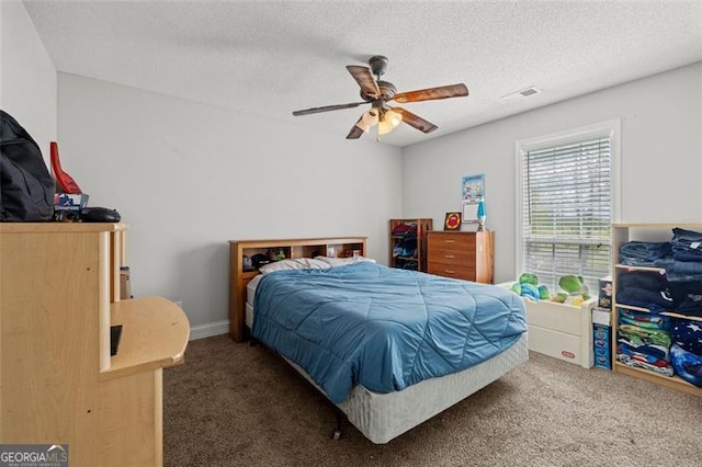 carpeted bedroom with ceiling fan and a textured ceiling