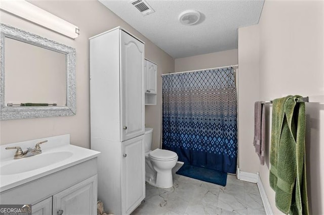 bathroom featuring vanity, a textured ceiling, toilet, and walk in shower