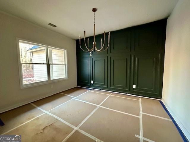 unfurnished dining area featuring a notable chandelier