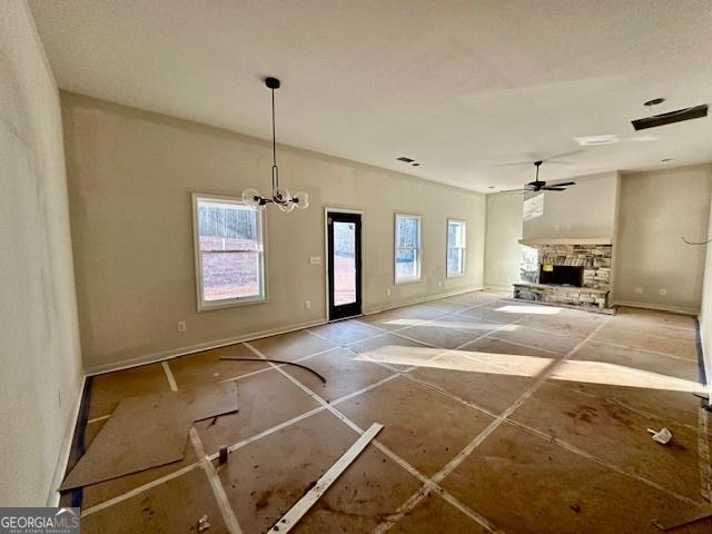 unfurnished living room featuring ceiling fan with notable chandelier and a fireplace