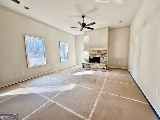 unfurnished living room with ceiling fan and a fireplace