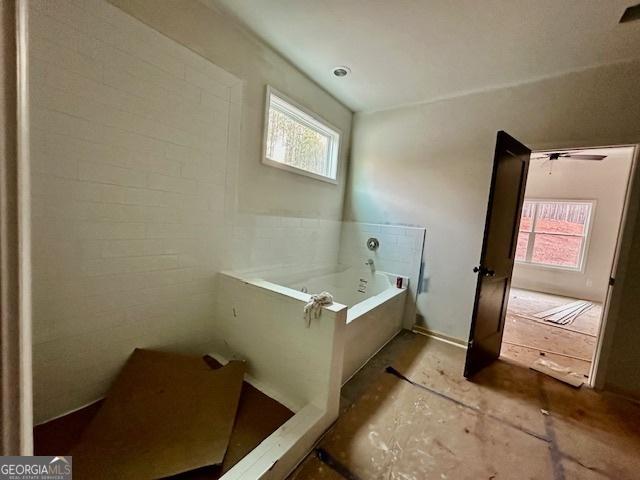 bathroom with a wealth of natural light and a tub