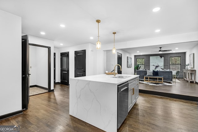 kitchen with sink, light stone counters, hanging light fixtures, dishwasher, and a kitchen island with sink