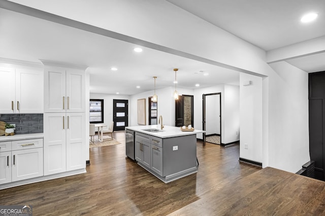 kitchen with dishwasher, hanging light fixtures, a center island with sink, and white cabinets