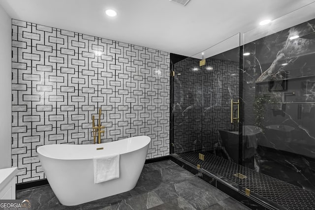 bathroom featuring shower with separate bathtub and tile walls