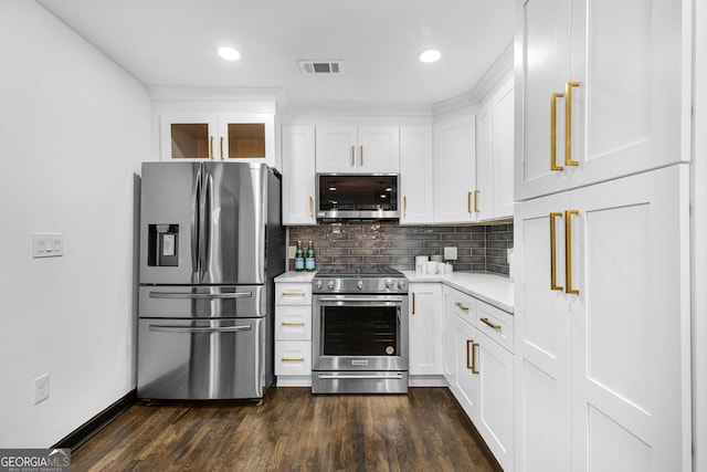 kitchen with decorative backsplash, dark wood-type flooring, white cabinets, and appliances with stainless steel finishes