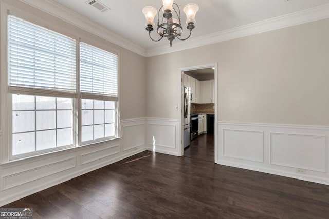 unfurnished dining area with an inviting chandelier, ornamental molding, and dark hardwood / wood-style floors