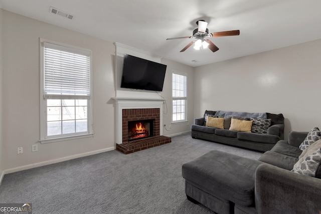 carpeted living room with ceiling fan and a brick fireplace